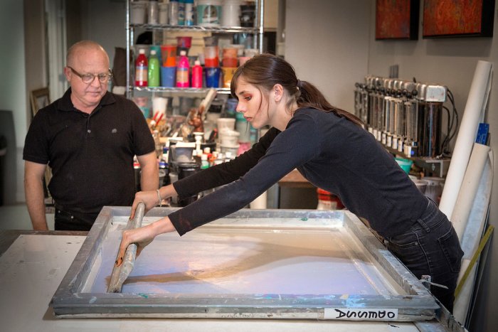 Emily McAvoy assists artist Walter Knabe with screen printing at his South Broad Ripple studio
