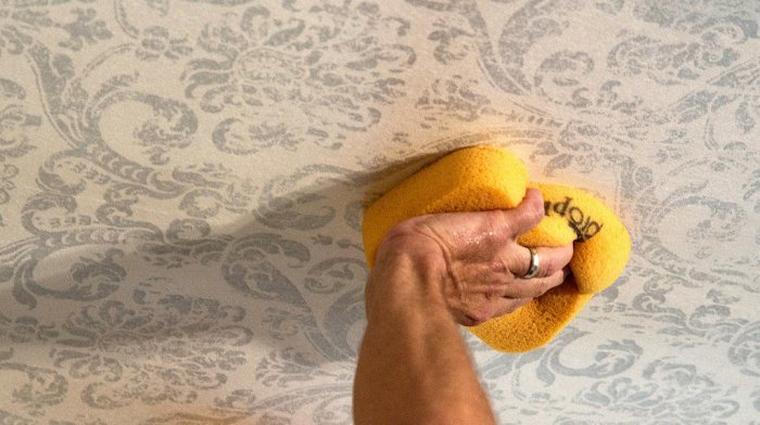 Walter Knabe custom wallpaper being affixed to his dining room ceiling