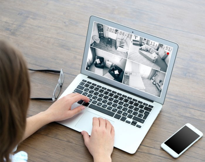 woman viewing home security video on laptop computer