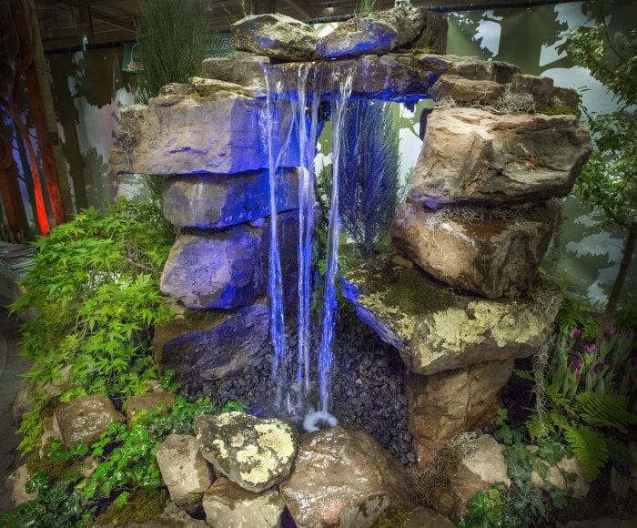 pondless waterfall above rocks with blue backlight