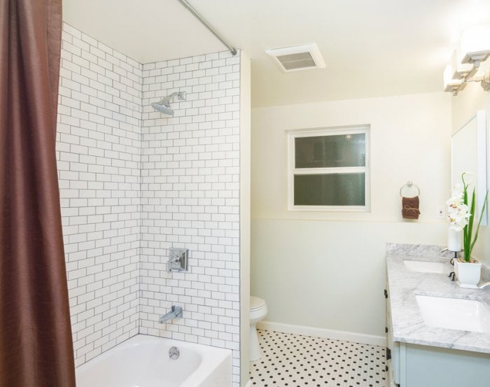 Bathtub and shower combo with subway tile and brown curtain
