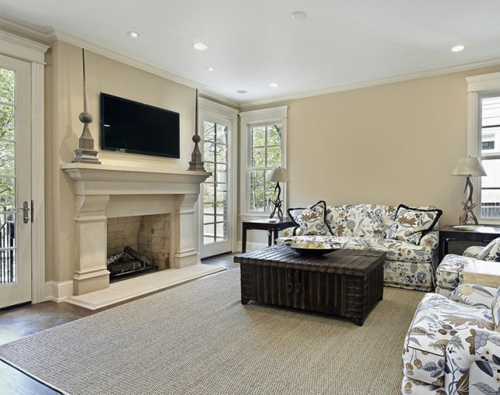 White, painted fireplace with two art sculptures flanking the TV mounted above