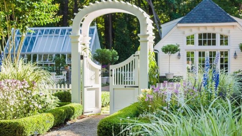 Sidewalk walkway with arch leading to front of home