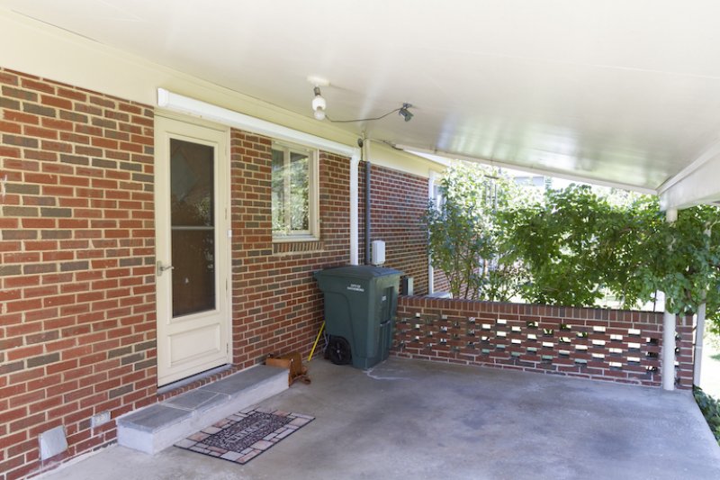 a plain brick and concrete carport entry way before the makeover (Photo by © Carrie Waller)