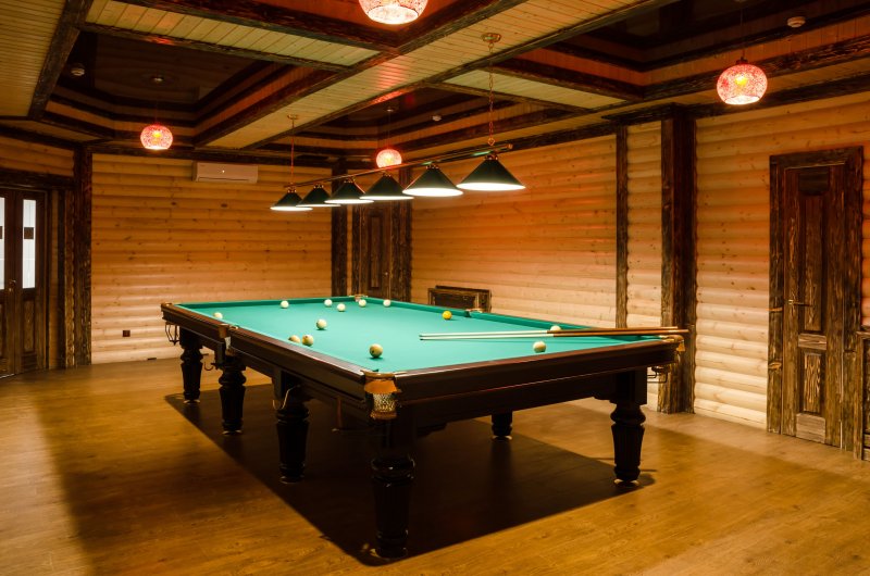 A basement room with a billiards table and wood plank ceiling (Photo by yanik88 - stock.adobe.com)