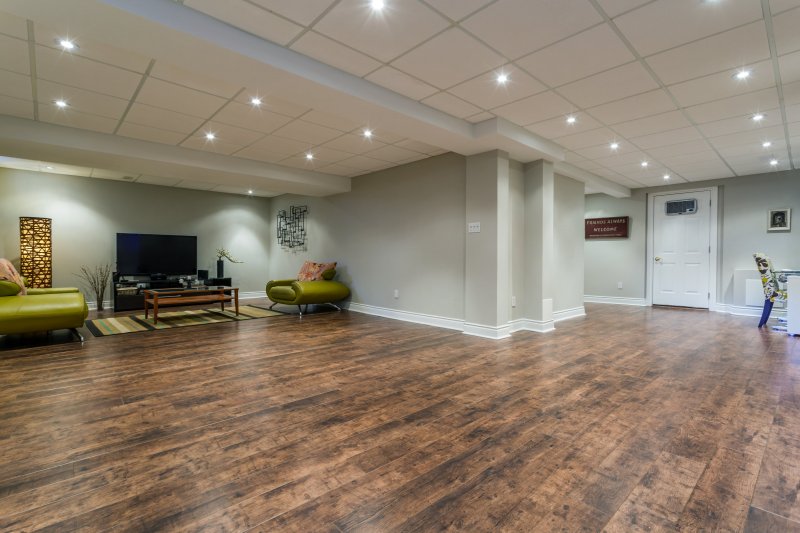 A finished basement with wood floors and ceiling tile (Photo by PhotoSerg - stock.adobe.com)