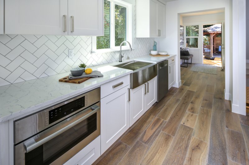 Kitchen with white herringbone backsplash and white cabinets (Photo by Javani LLC - stock.adobe.com)