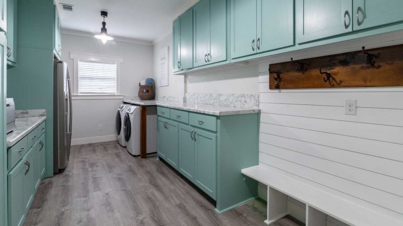 Mint green and white laundry room with a white shiplap bench (Photo by AdrieDee - stock.adobe.com)
