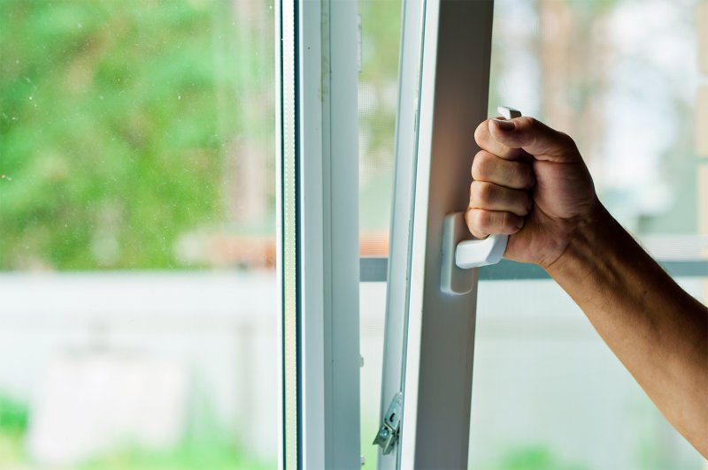 Person opening a window (Photo by Ruslan Solnstev via Getty Images)