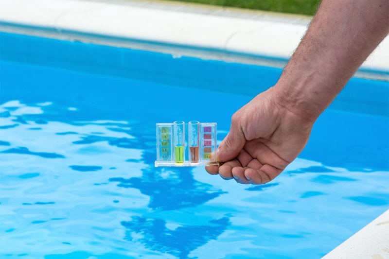 Man testing ph levels of pool (Photo by strannik9211 - stock.adobe.com)