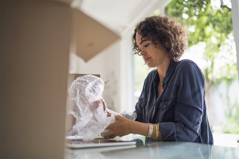 Woman wrapping belongings in bubble wrap for moving (Photo by Portra/Digital Vision via Getty Images)