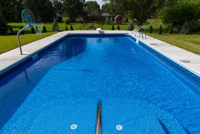 Rectangle in-ground pool with diving board and basketball goal