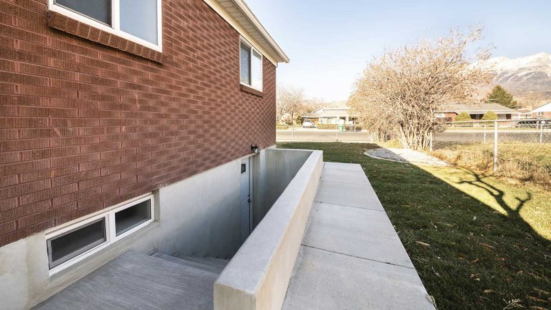 Exterior of a house with a basement entrance (Photo by Jason - stock.adobe.com)