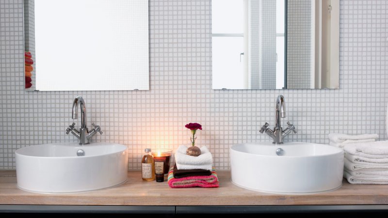 A bright bathroom with double sinks and white tiles (Photo by Carlsson, Peter via Getty Images)