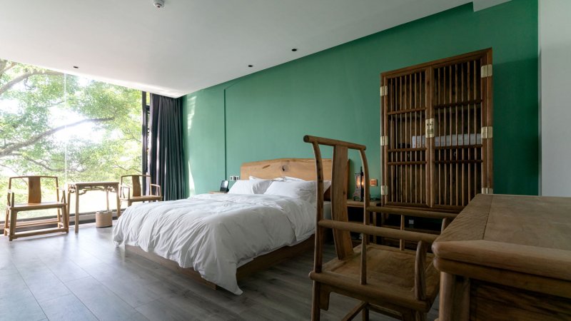 Wooden furniture in a green painted bedroom (Photo by zhihao/Moment via Getty Images)