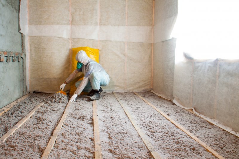 person adding cellulose insulation to floor of home (Photo by © mironovm - stock.adobe.com)