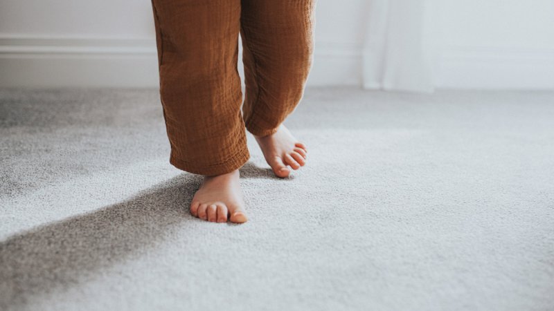 Close-up of a child taking a step on a thick carpet (Photo by Catherine Falls Commercial/Moment via Getty Images)