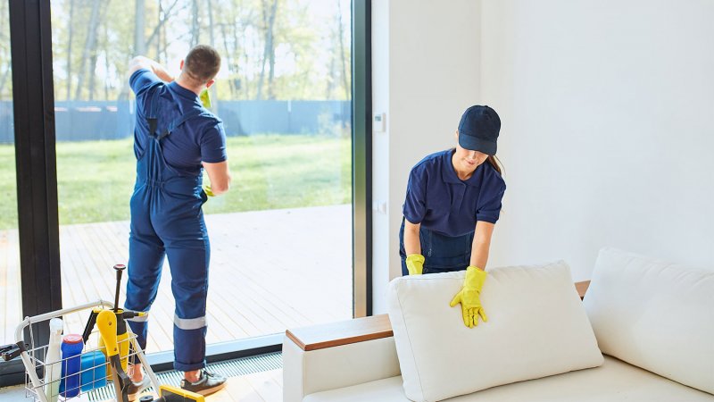 cleaning team in uniform cleaning living room (Photo by alfa27 – stock.adobe.com)