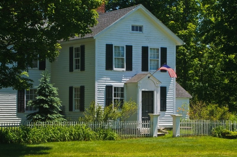 Colonial style house with flag (Photo by KenWiedemann / E+ via Getty Images)