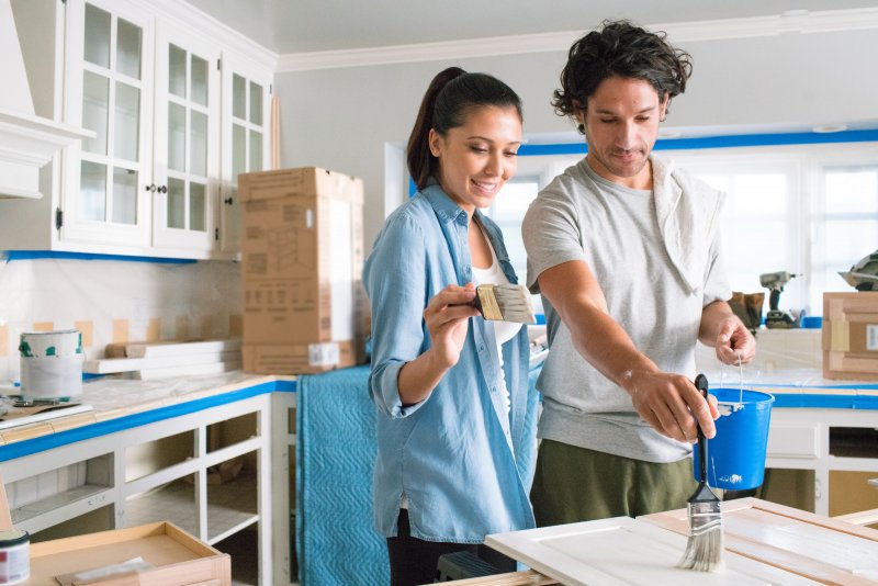 Couple painting cabinets white (Photo by Jeffrey Markowitz /Corbis via Getty Images)
