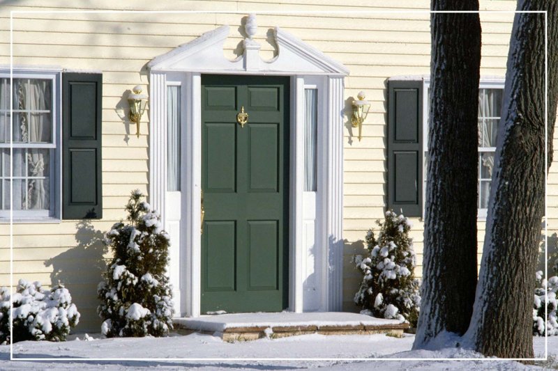 dark green front door in winter (Photo by Jupiterimages/liquidlibrary via Getty Images)