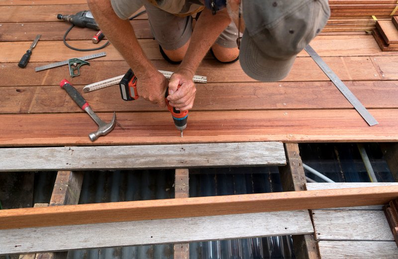 man fixing deck with drill (Photo by RobynRoper/iStock/Getty Images Plus via Getty Images)