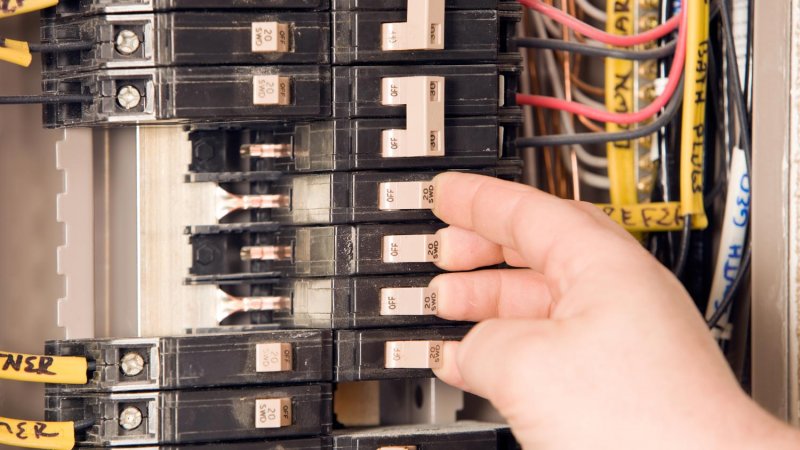 Close-up of an electrician turning on circuit breakers (Photo by BanksPhotos/E+ via Getty Images)