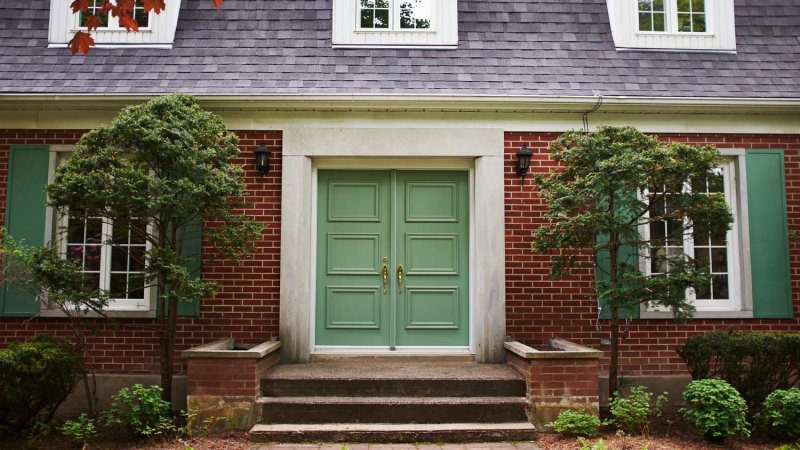 The exterior of a house with a double front door (Photo by Kathleen Finlay/Image Source via Getty Images)