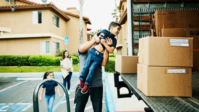 Father lifts son into moving truck (Photo by Thomas Barwick/DigitalVision via Getty Images)