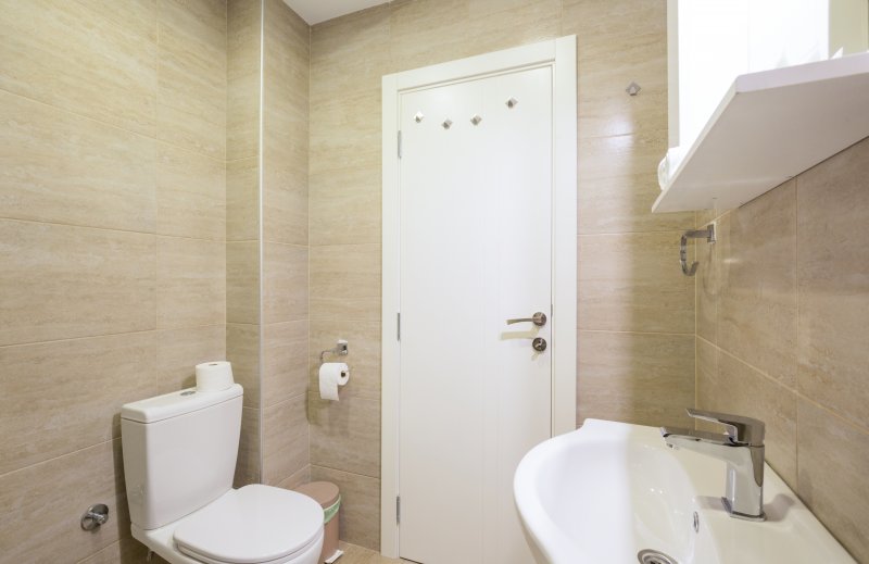 Small bathroom with floor to ceiling beige tiles (Photo by rilueda – stock.adobe.com)