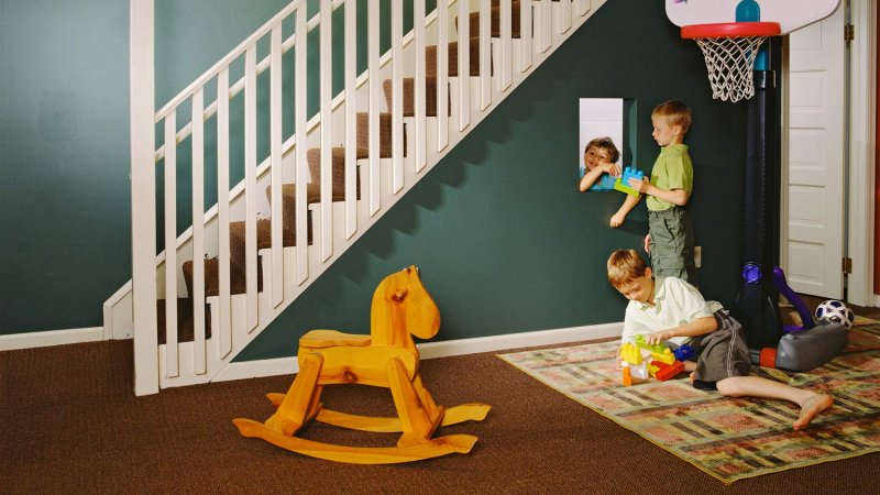 A green painted basement used as a playroom by two children (Photo by Andrea Rugg/The Image Bank via Getty Images)