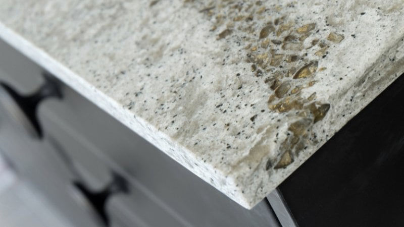 Close up of grey quartz countertop and black kitchen cabinets (Photo by Papah-kah/Shutterstock.com)