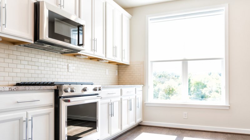 A kitchen interior with a microwave above the gas stove (Photo by Andriy Blokhin - stock.adobe.com)