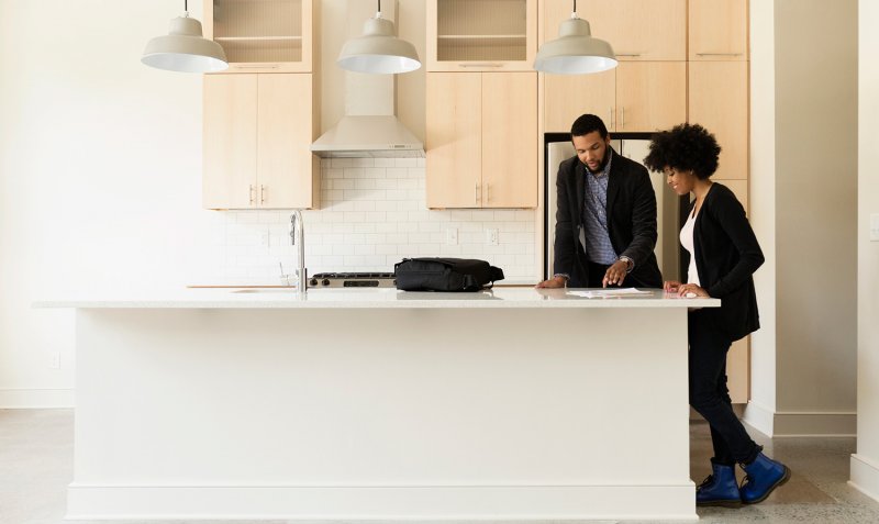 Man and woman look over paperwork in new house (Photo by Roberto Westbrook via Getty Images)