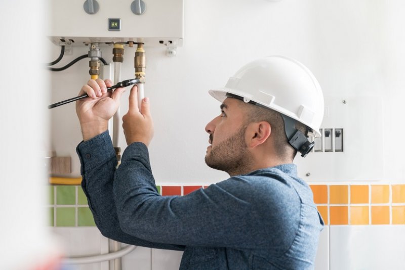 Man draining water heater (Photo by © Hispanolistic / E+ / Getty Images)