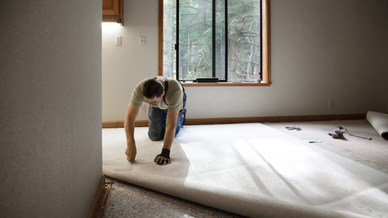 A man installing carpeting at a house (Photo by bill oxford/iStock / Getty Images Plus via Getty Images)