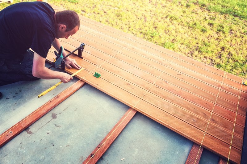 man measuring and building wooden deck (Photo by Avalon_Studio/E+/Getty Images.)