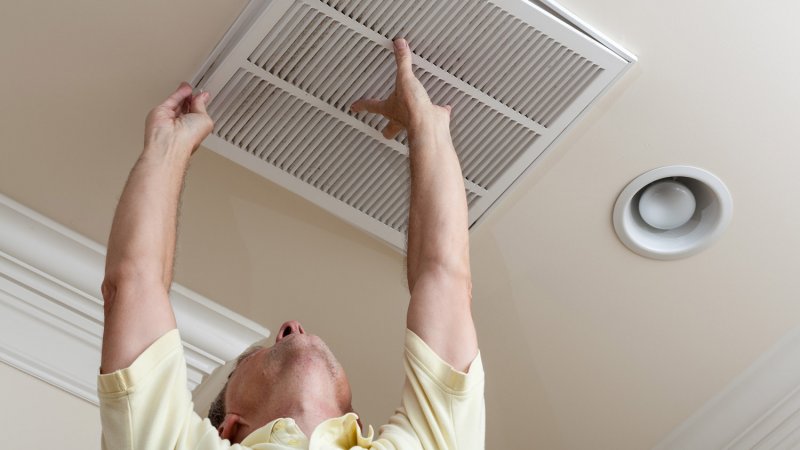 A senior man placing back an air duct (Photo by Steven Heap/EyeEm/EyeEm via Getty Images)