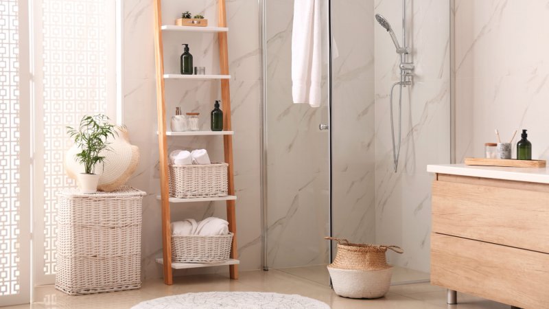 A modern bathroom with a shower stall and a decorative ladder (Photo by Liudmila Chernetska/iStock via Getty Images)
