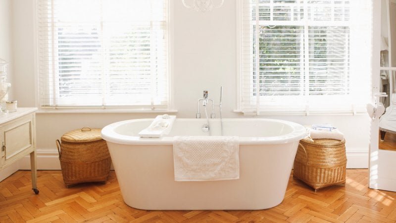 A modern bathtub in a sunlit bathroom (Photo by Daly and Newton/OJO Images via Getty Images)
