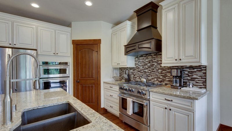 Modern white kitchen with stainless steel appliances (Photo by irina88w / iStock / Getty Images Plus via Getty Images)
