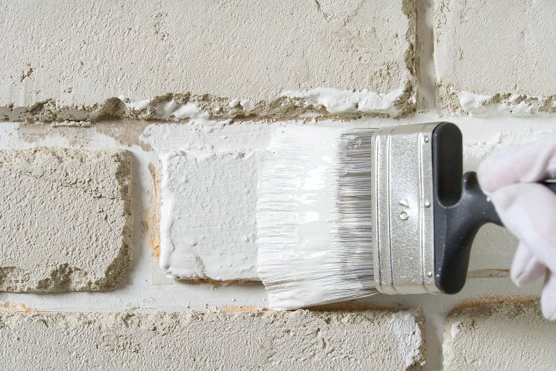 Painting brick white with paintbrush (Photo by Ilja Enger-Tsizikov /iStock /Getty Images Plus via Getty Ima)