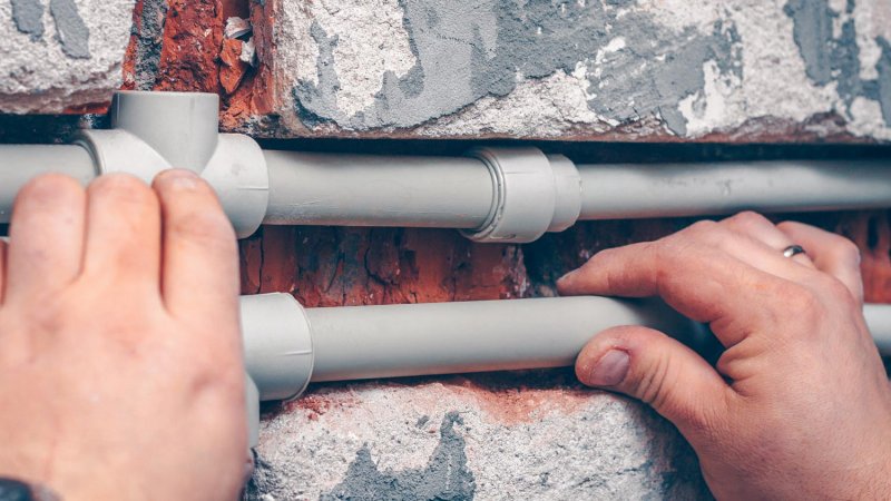 A worker’s hand adjust PEX pipes (Photo by andrey gonchar - stock.adobe.com)