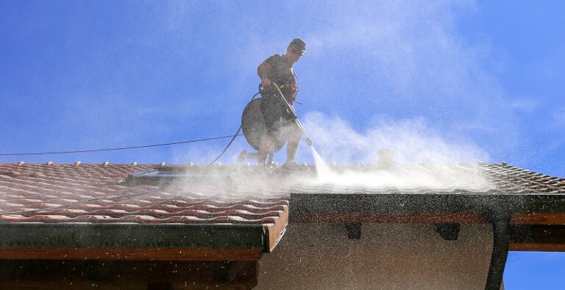 professional roof washer power washing (Photo by Marina Lohrbach / IStock / Getty Images Plus)