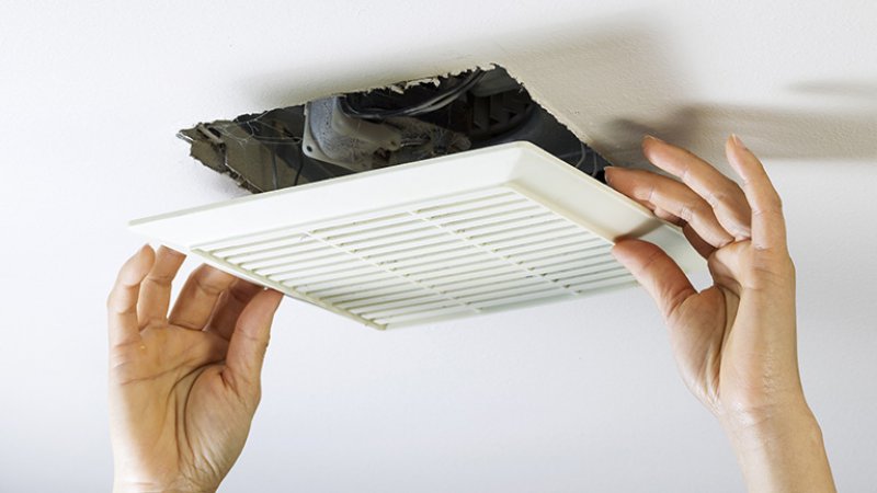 Detail of a professional’s hands while installing an exhaust fan (Photo by tab62 - stock.adobe.com)