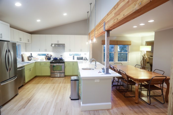 open kitchen with white subway tile and exposed wood