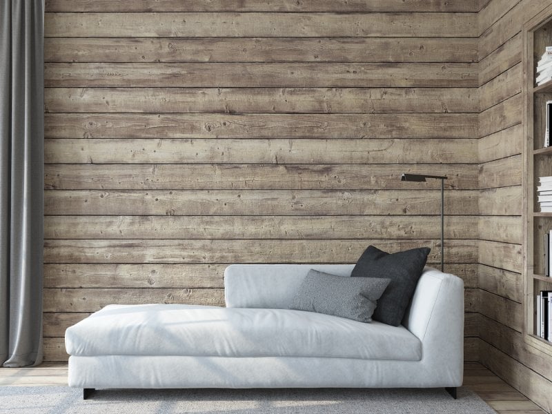 Living room with a gray couch in front of rustic wood shiplap walls and built-in bookshelves (Photo by poligonchik - stock.adobe.com)