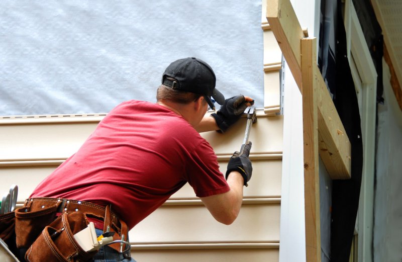 contractor working on home siding (Photo by Bonita R. Cheshier/Shutterstock.com)