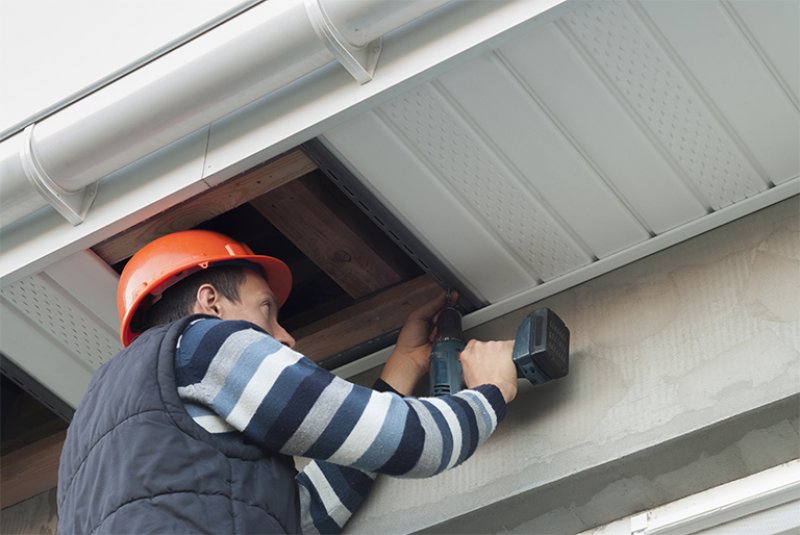 Repairman fixing soffit of house (Photo by kuchina - stock.adobe.com)