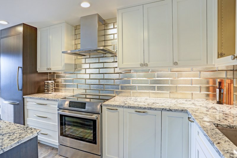 Kitchen with stainless subway tile backsplash and white cabinets (Photo by Javani LLC - stock.adobe.com)